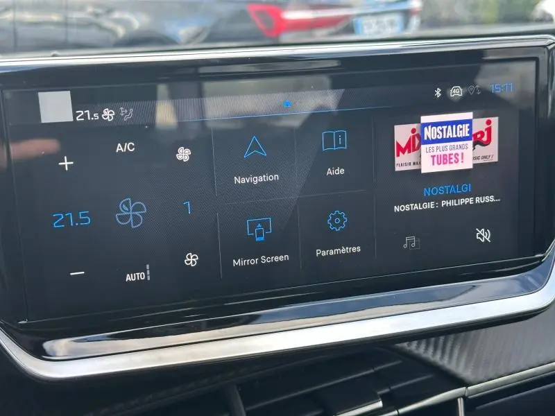 Écran tactile central du tableau de bord du Peugeot 2008 bleu, affichant navigation et réglages climatisation.
