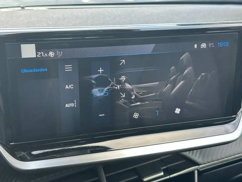 Écran tactile intérieur du Peugeot 2008 Hybrid 2025 montrant les réglages de climatisation et la vue latérale des sièges noirs.