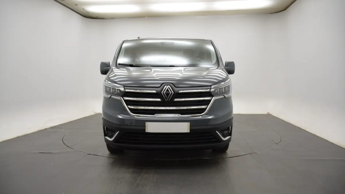 Vue frontale du Renault Trafic Fourgon gris clair, mettant en valeur sa calandre chromée et ses phares LED.