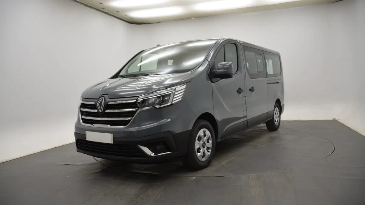 Renault Trafic Fourgon gris clair vu en 3/4 avant droit, avec calandre chromée et phares LED distinctifs.