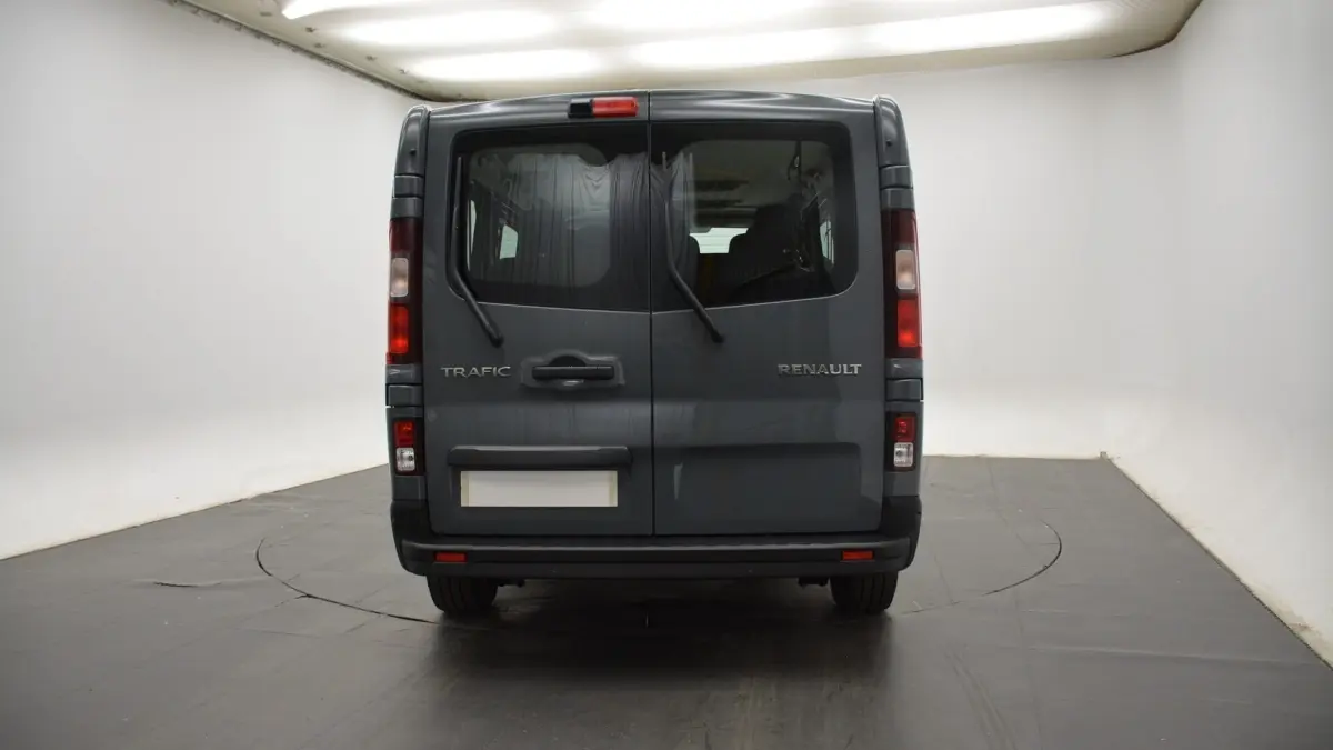 Vue arrière du Renault Trafic Fourgon gris clair avec portes battantes et essuie-glaces intégrés aux vitres arrière.