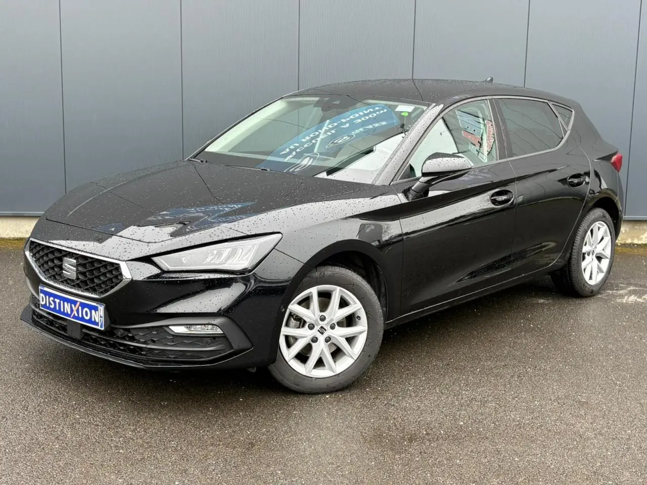 SEAT Leon 2024 noir Minuit vue 3/4 avant droit, avec jantes alliage 16 pouces et carrosserie brillante mouillée.