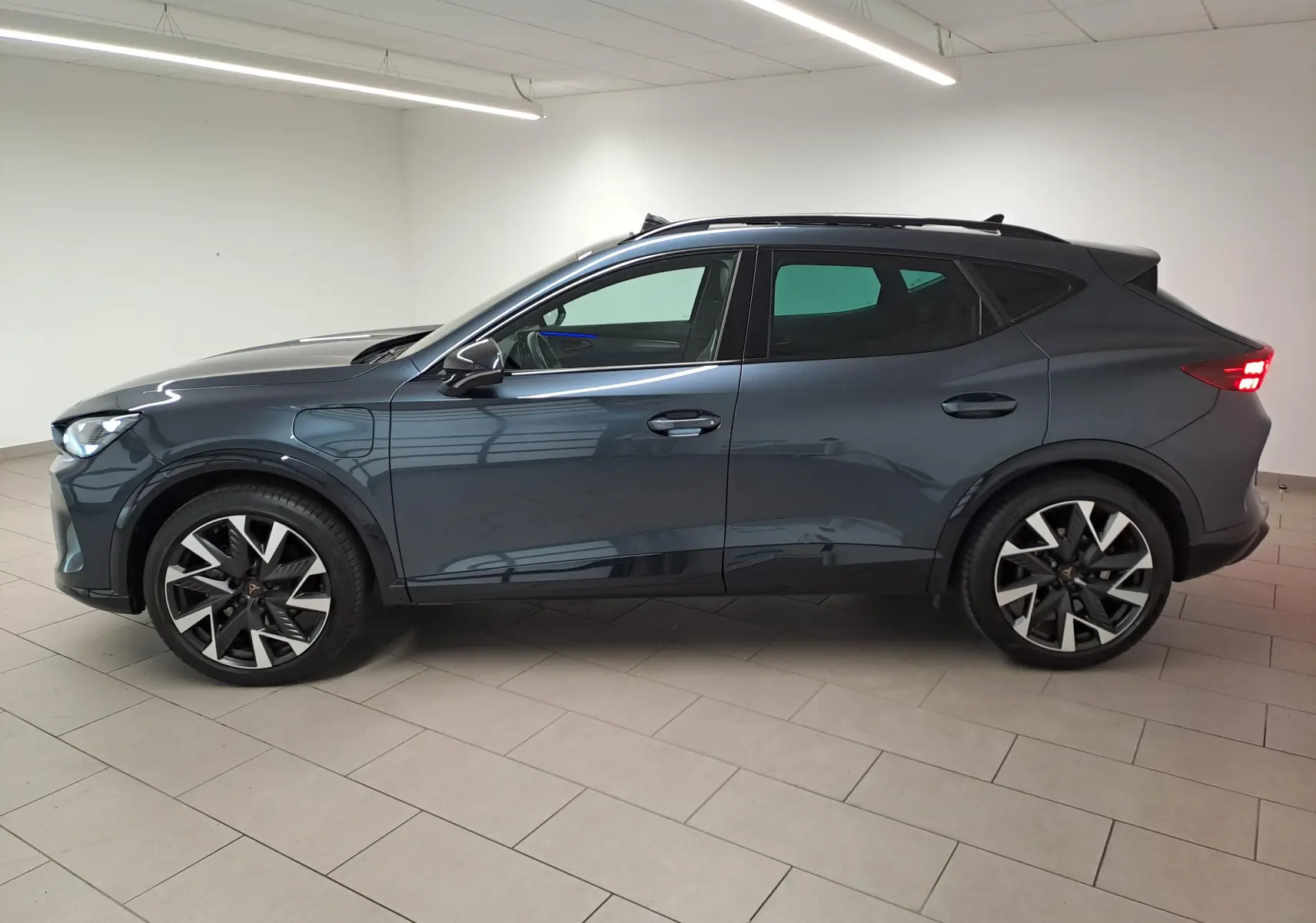 Vue de profil côté gauche d'une CUPRA Formentor gris magnétique avec jantes alliage 19'' et toit ouvrant panoramique.