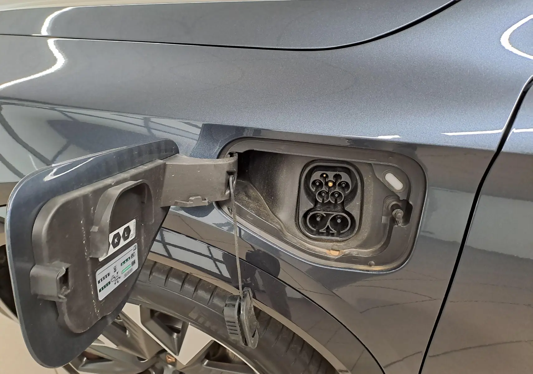 Détail de la trappe de recharge côté gauche du CUPRA Formentor gris magnétique avec jante alliage 19 pouces visible.