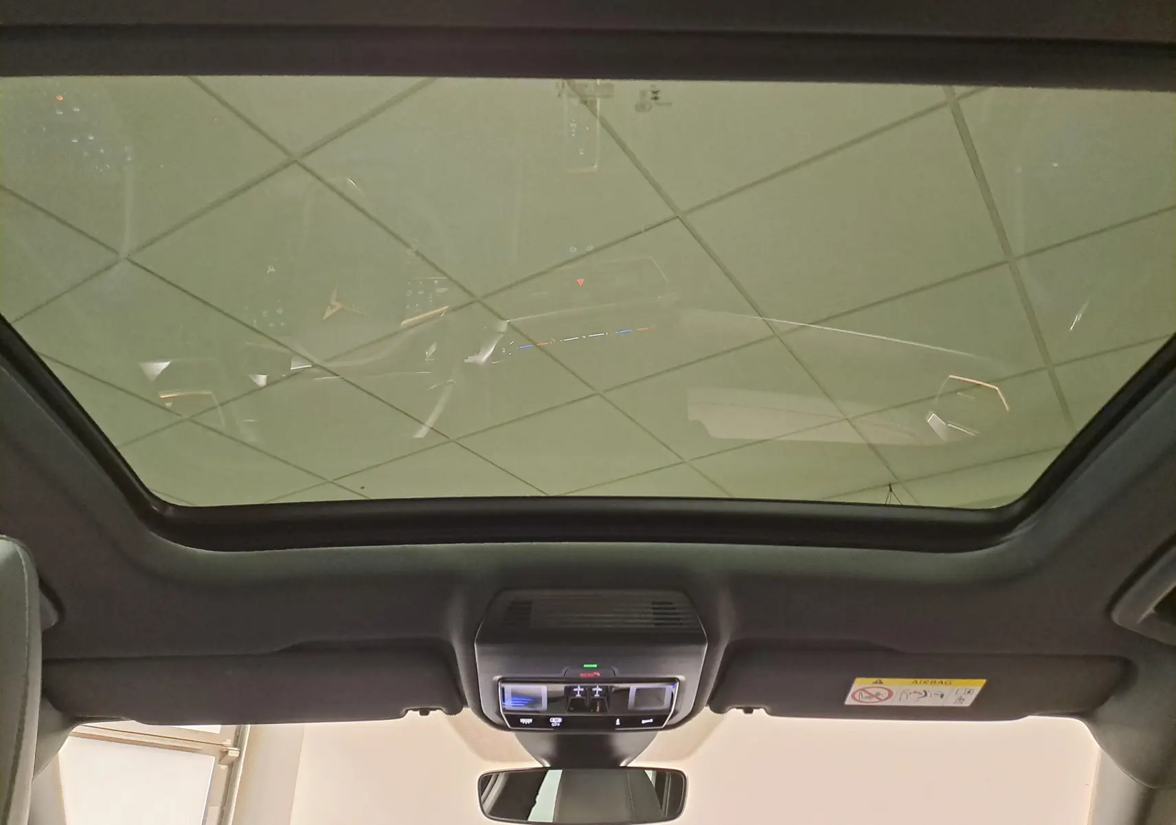 Vue intérieure du toit ouvrant panoramique du CUPRA Formentor gris magnétique, avec commandes lumineuses au plafond.