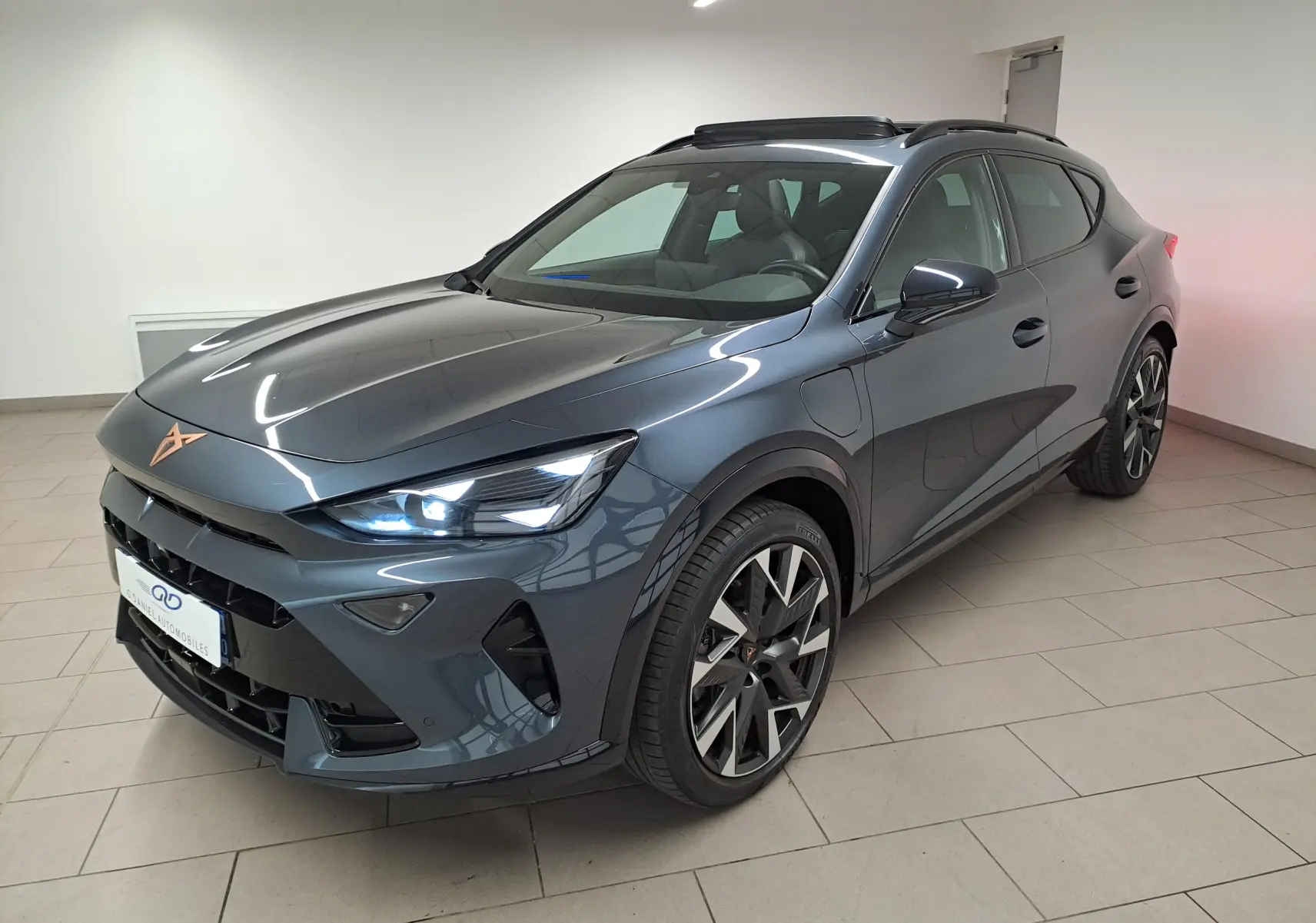 Vue 3/4 avant d'une CUPRA Formentor gris magnétique avec jantes alliage 19'' et toit ouvrant panoramique visible.