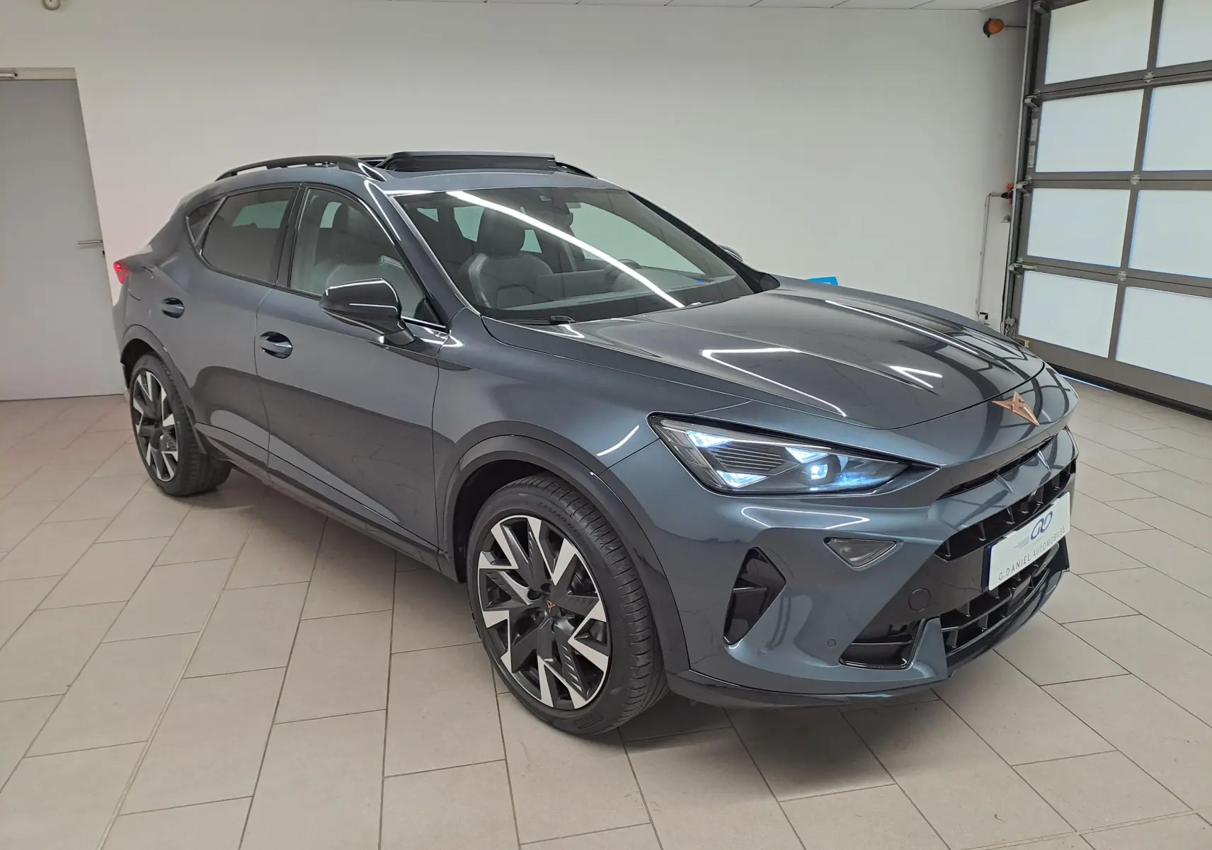 Vue 3/4 avant droite du CUPRA Formentor gris magnétique avec jantes alliage 19'' et toit ouvrant panoramique.