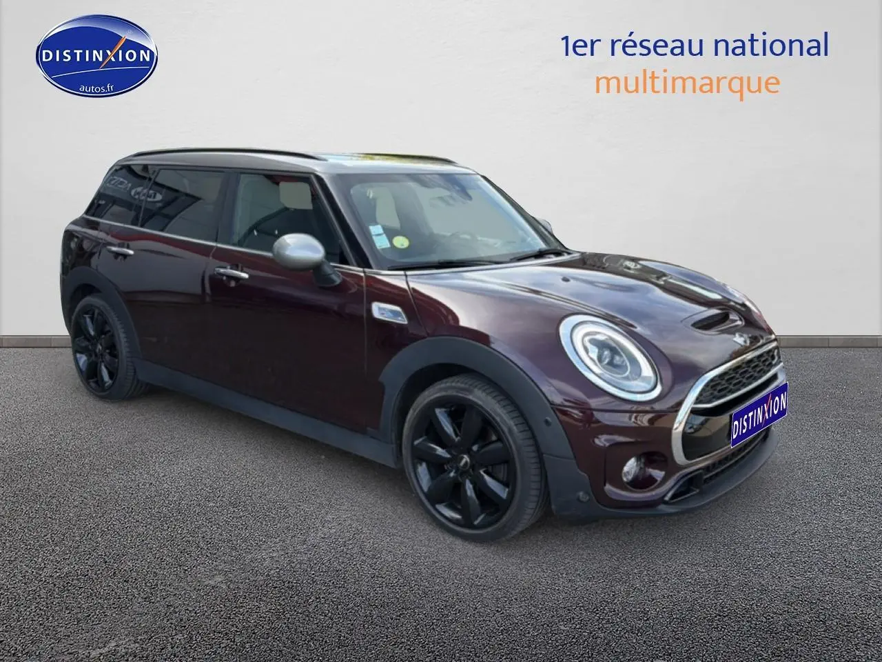 Vue 3/4 avant droit d'une MINI Clubman Cooper SD bordeaux avec jantes noires et toit panoramique en verre.