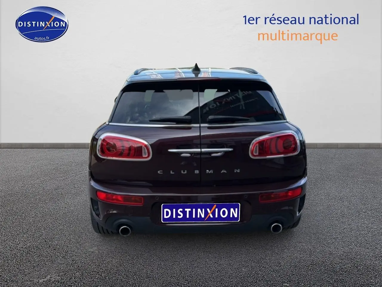 Vue arrière d'une MINI Clubman bordeaux avec double sortie d'échappement et portes battantes distinctives.