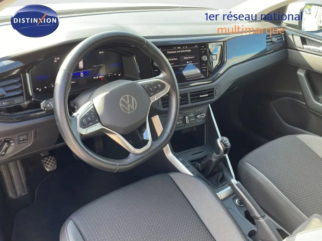 Vue intérieure du poste de conduite du Volkswagen Taigo 2022, volant multifonction et levier de vitesses manuel visibles.