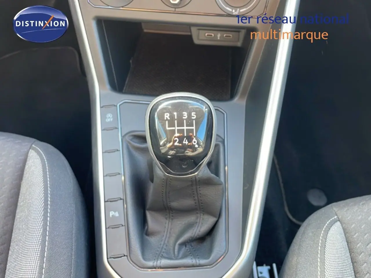 Gros plan sur le levier de vitesse manuel du Volkswagen Taigo 2022 en tissu noir, entouré de la console centrale grise.