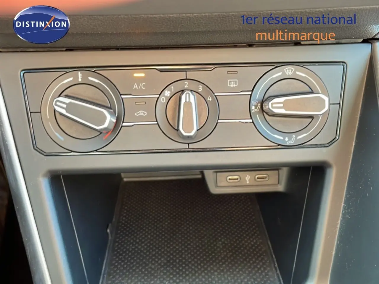 Vue rapprochée du tableau de bord de la Volkswagen Taigo 2022, montrant les commandes de climatisation et deux ports USB.