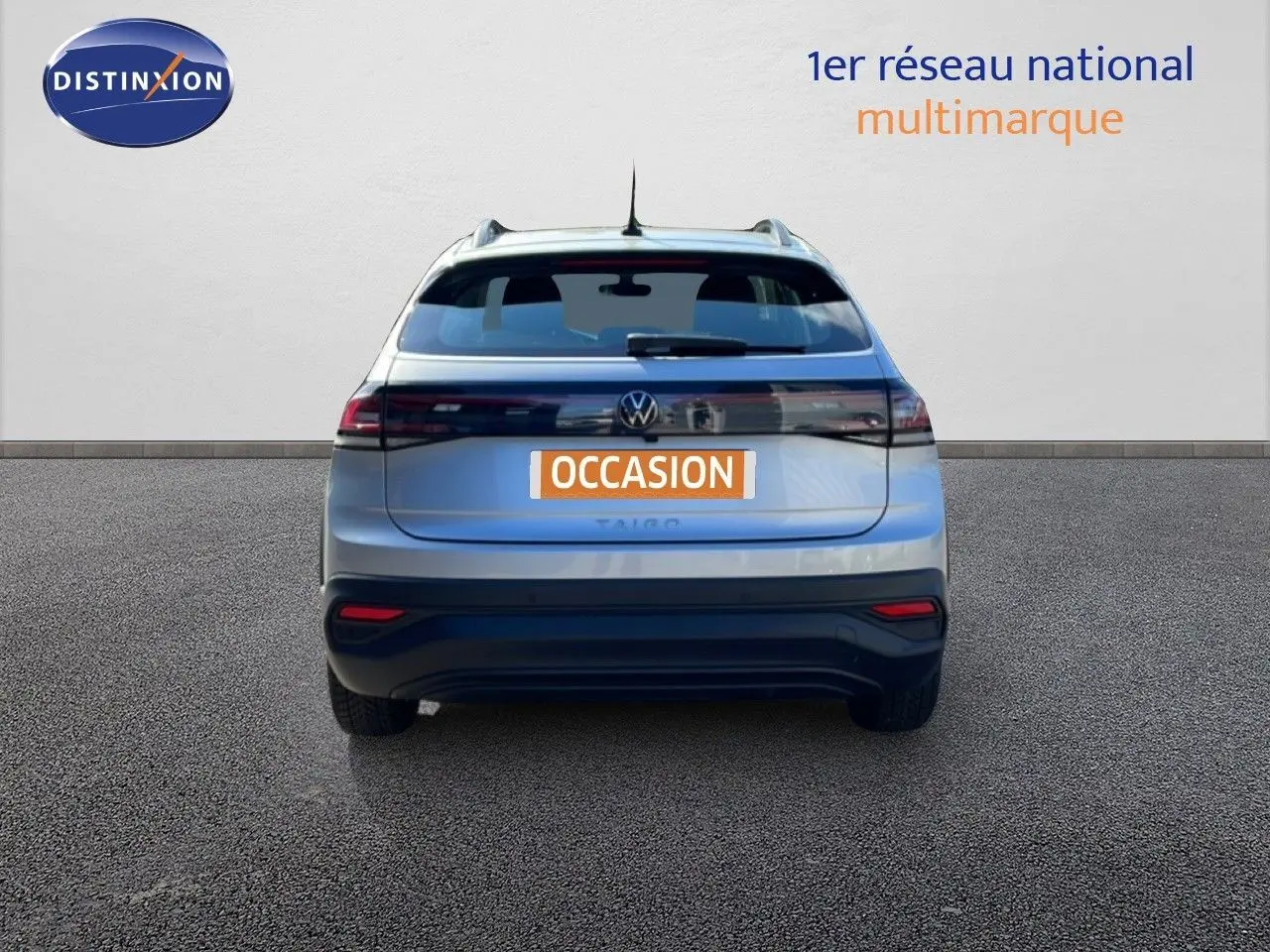 Vue arrière d'un Volkswagen Taigo 1.0 TSI 110CH Life Business en reflet d'argent métal, avec feux LED et plaque "OCCASION".