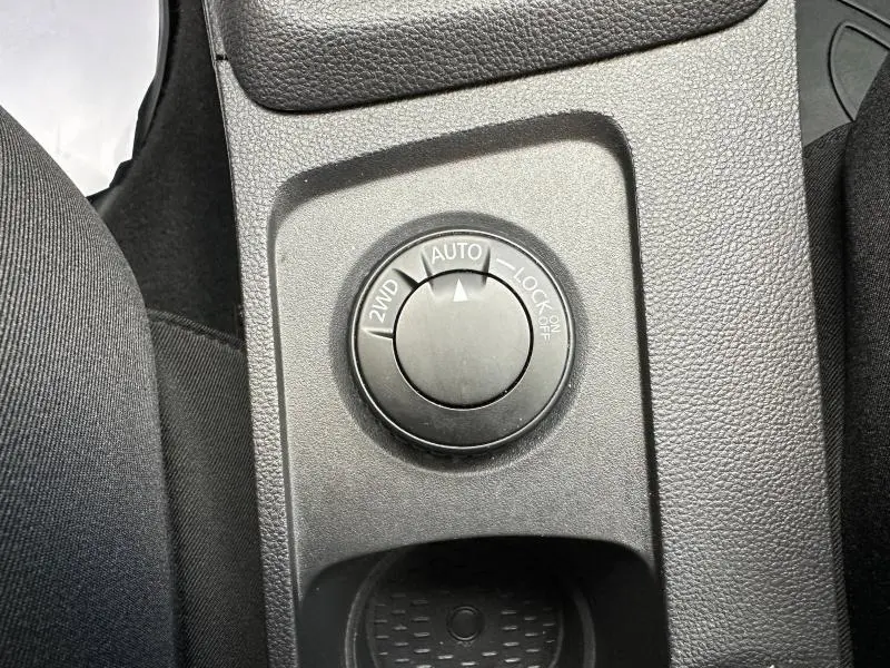 Gros plan sur la molette de sélection 2WD, Auto et Lock du système 4x4 du Dacia Duster blanc intérieur noir.