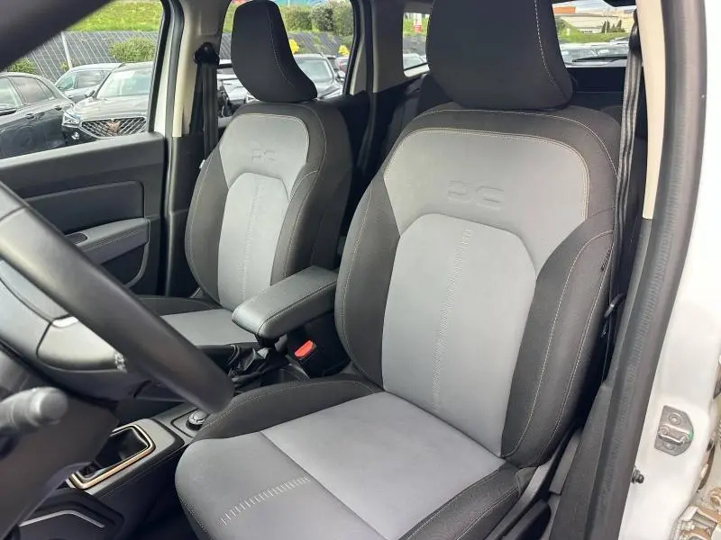 Vue intérieure des sièges avant gris et noir avec surpiqûres cuivrées du Dacia Duster blanc 2024 version Extreme 4x4