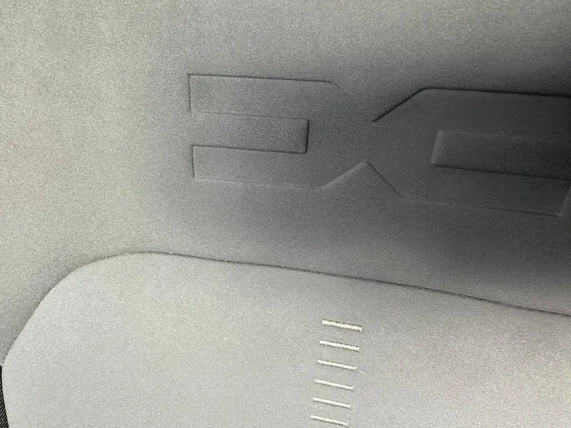 Gros plan sur le tissu gris foncé de la banquette arrière du Dacia Duster 2024 version Extreme avec surpiqûres brunes.