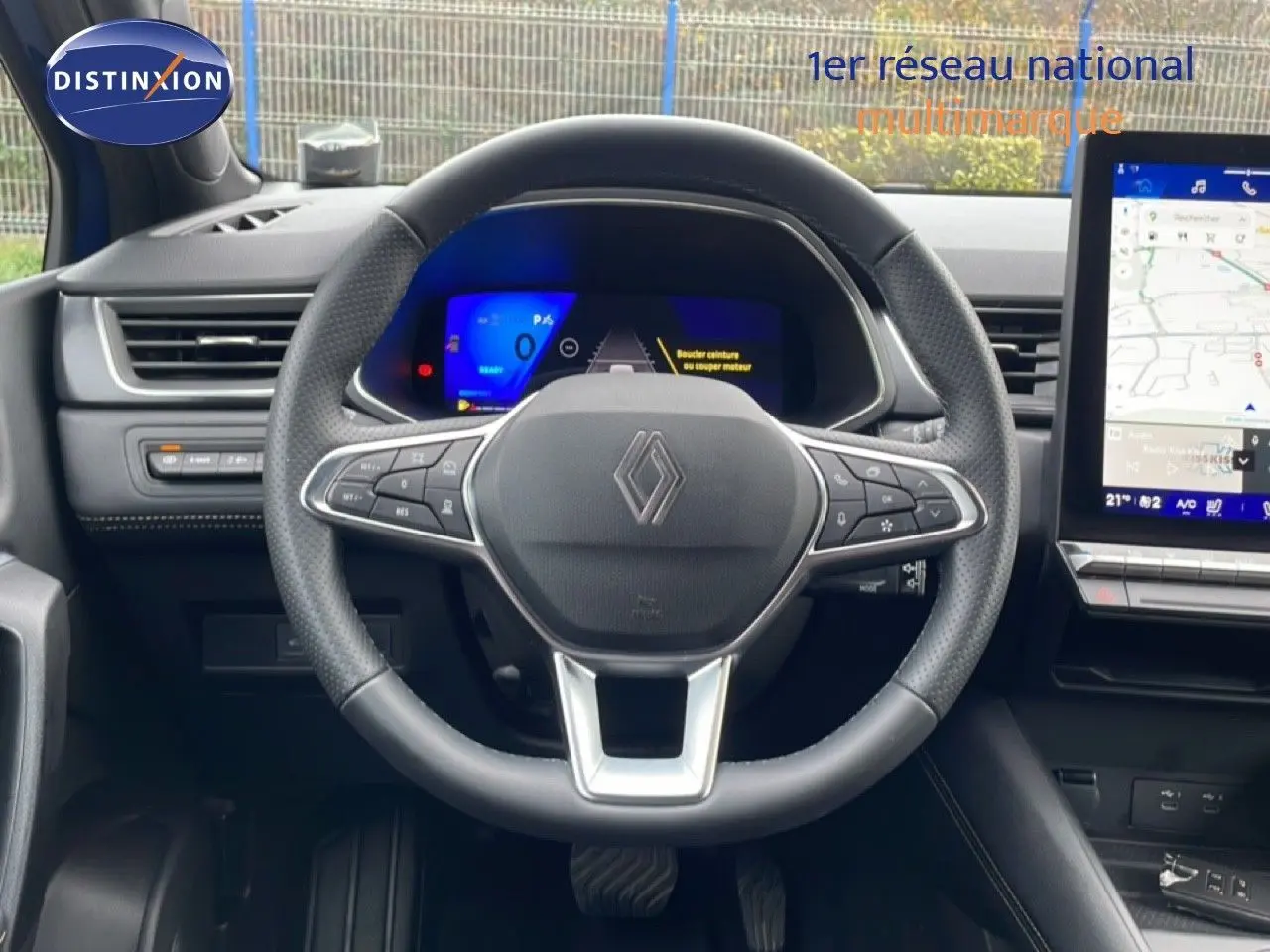 Vue intérieure centrée sur le volant Renault Symbioz E-Tech Full Hybrid 145ch Iconic avec tableau de bord numérique et écran tactile.