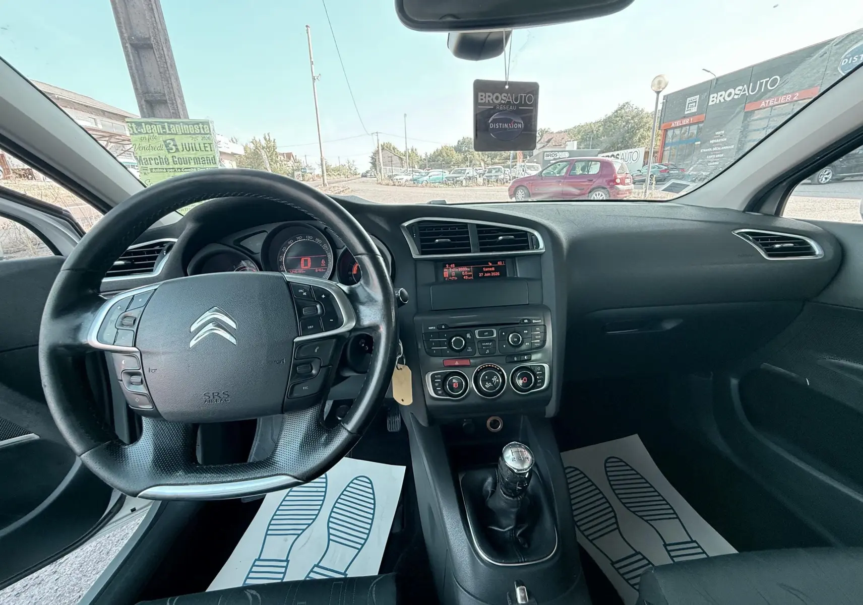 Vue intérieure avant de la Citroën C4 1.6 HDI gris, volant multifonction et levier de vitesses manuel visibles.