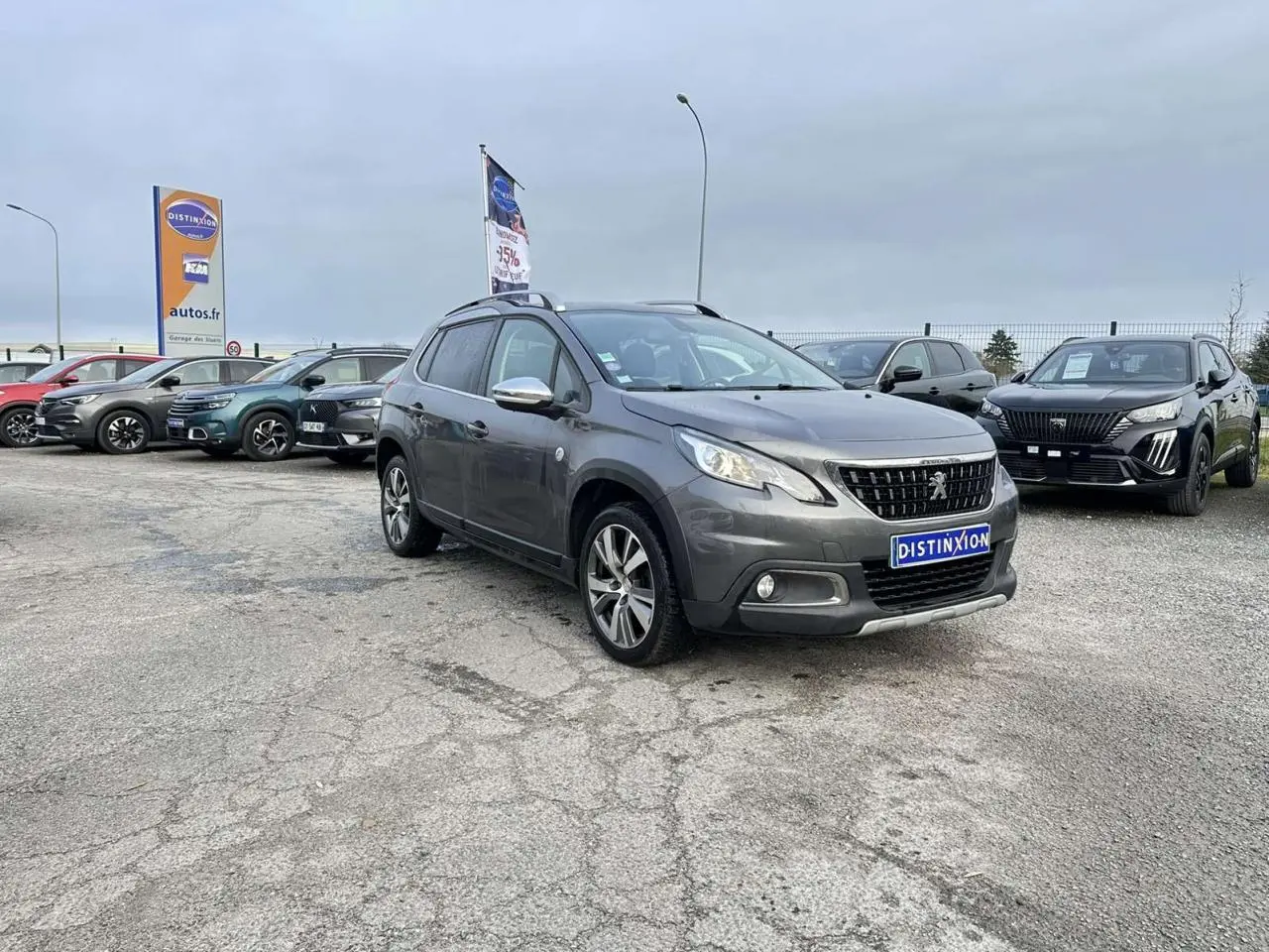 Peugeot 2008 gris foncé en 3/4 avant droit, avec coques de rétroviseurs chrome brillant et jantes aluminium 17''.