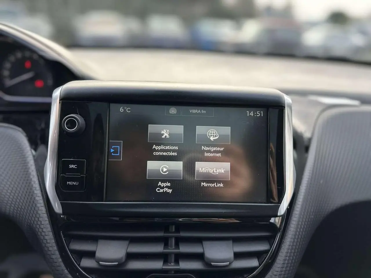 Écran tactile central de la Peugeot 2008 gris foncé, vue intérieure frontale avec commandes multimédia visibles.