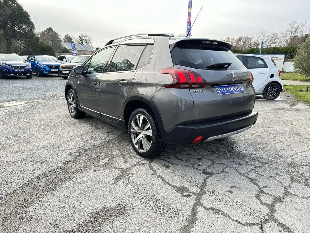Peugeot 2008 gris foncé vue 3/4 arrière droit, avec jantes aluminium et badges Crossway visibles.