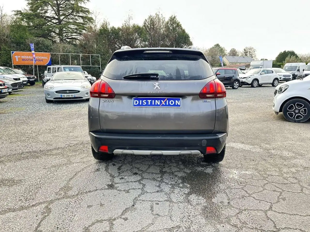 Vue arrière d’un Peugeot 2008 Crossway gris foncé avec badges latéraux et caméra de recul visible en extérieur.