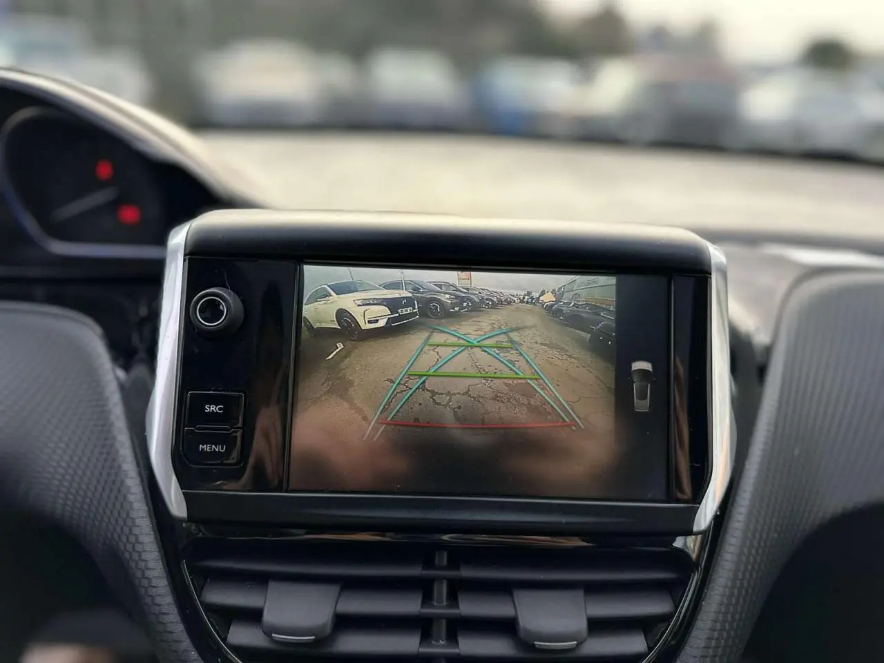 Écran tactile intérieur montrant la caméra de recul d'une Peugeot 2008 gris foncé, vue de face du tableau de bord.