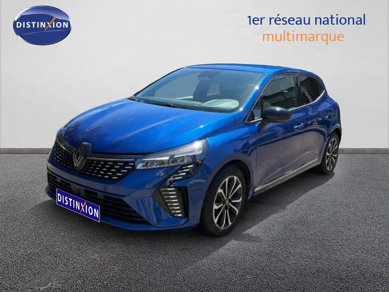 Renault Clio 2025 bleu Iron Metal vue 3/4 avant droit, avec calandre distinctive et jantes alliage noires.