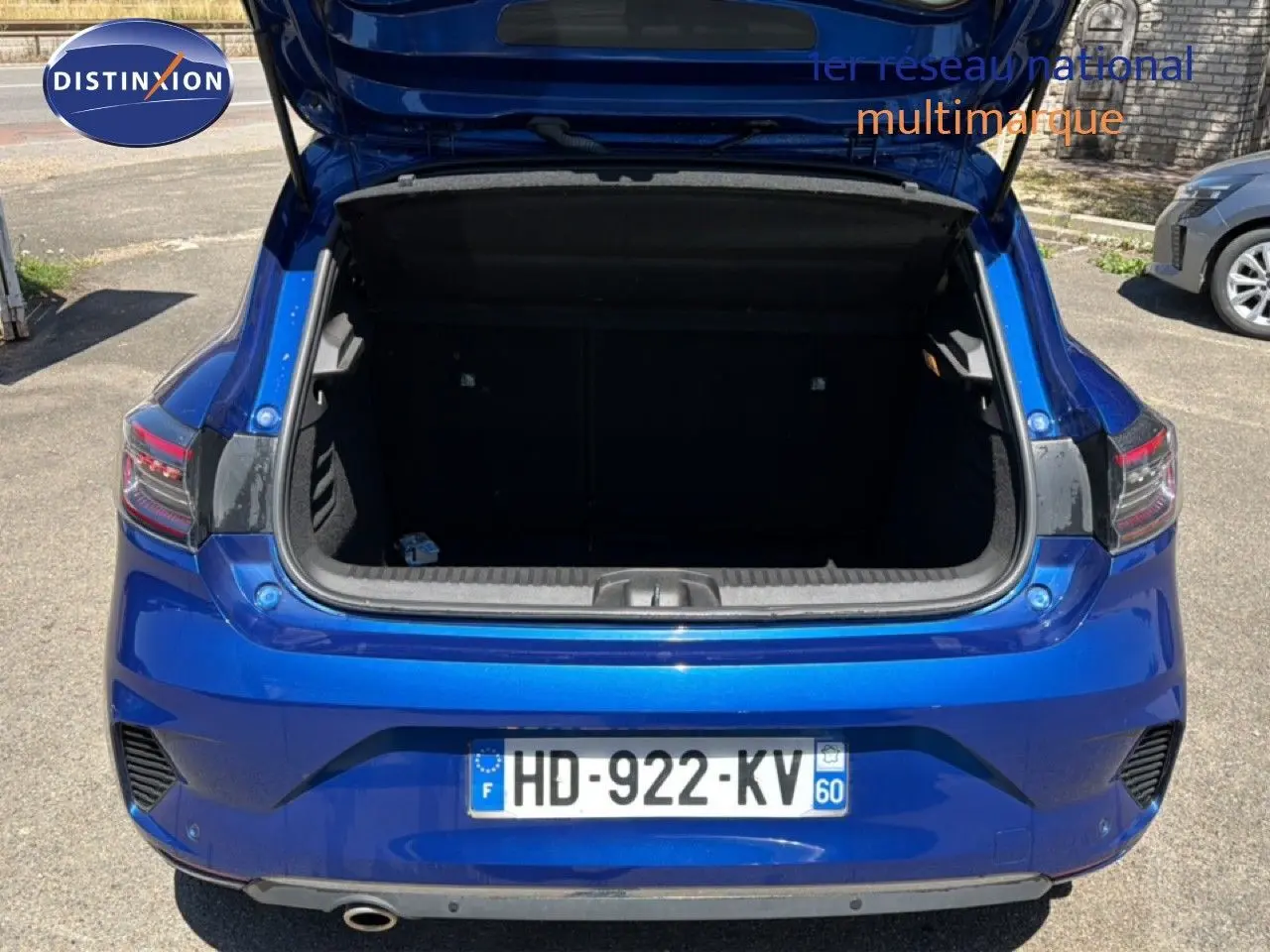 Vue arrière de la Renault Clio 2025 bleu iron metal avec coffre ouvert, mettant en valeur son espace de chargement.