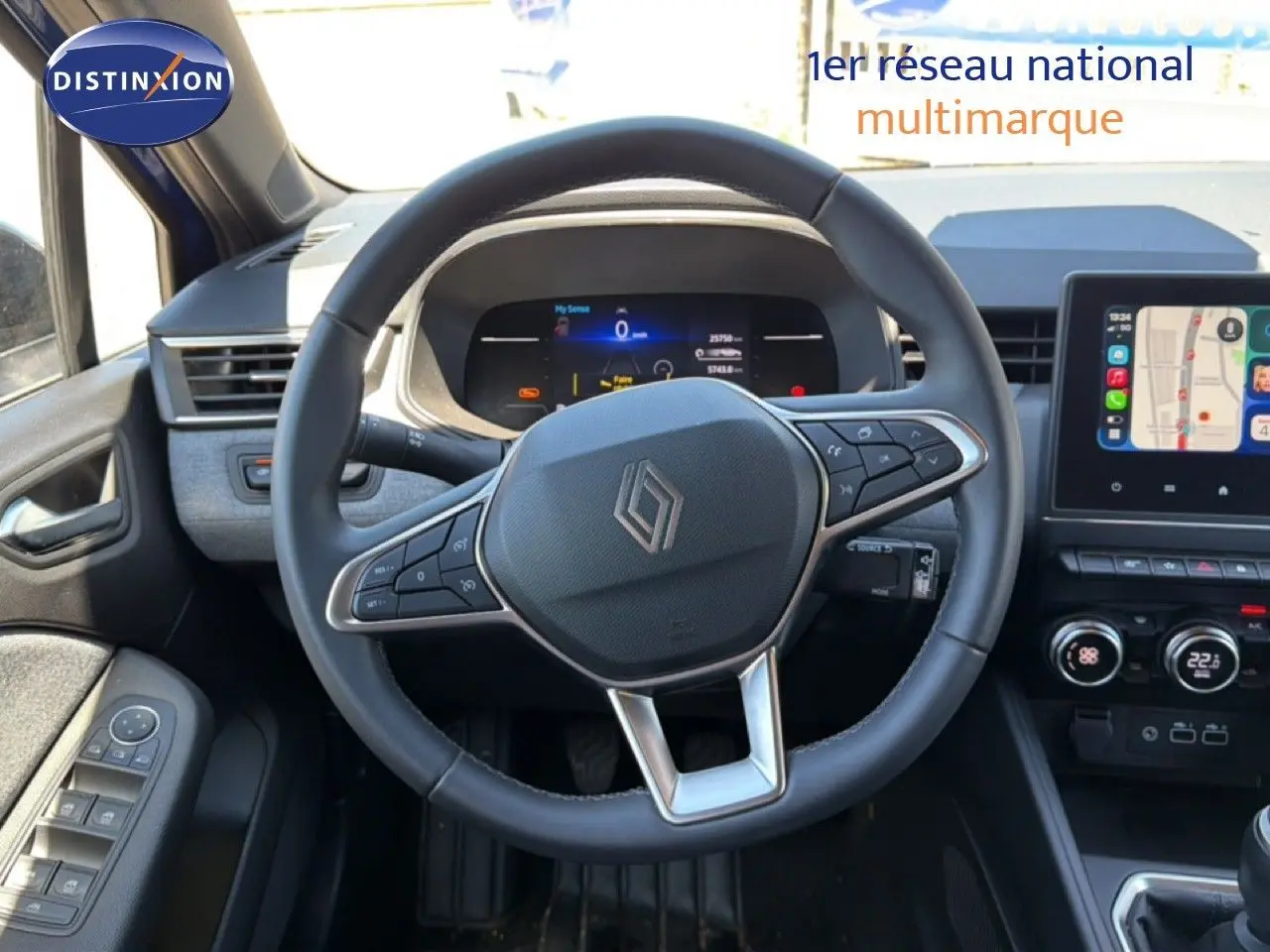 Vue intérieure centrée sur le volant cuir de la Renault Clio 2025, avec tableau de bord numérique et écran tactile GPS.
