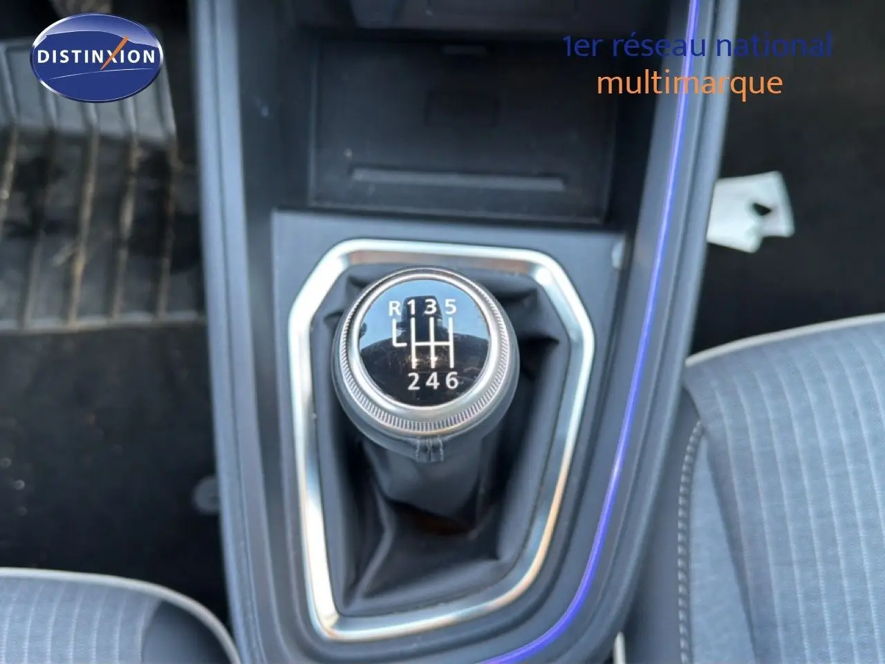 Gros plan sur le levier de vitesses manuel de la Renault Clio 2025, intérieur tissu gris avec surpiqûres visibles.