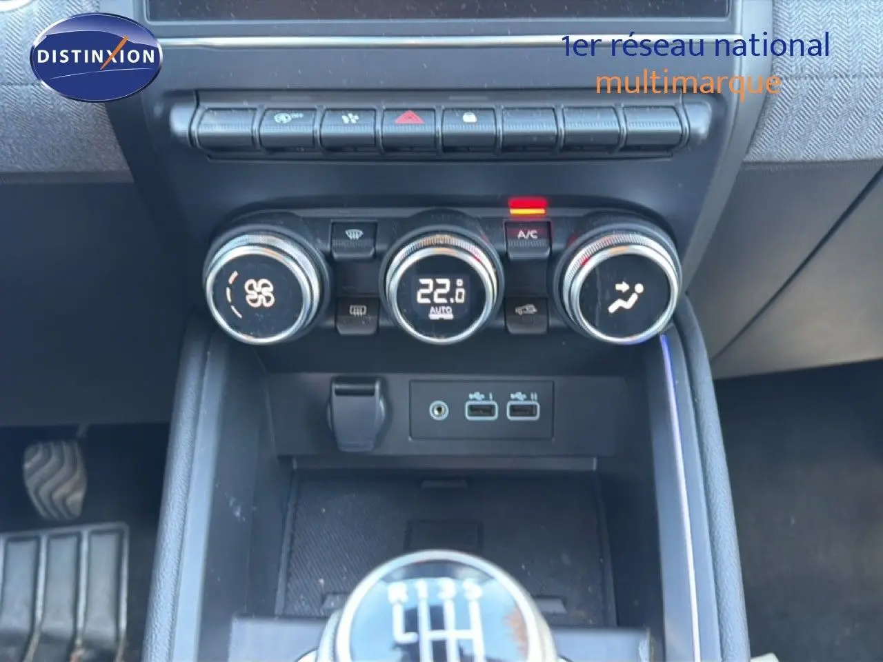 Gros plan sur la console centrale de la Renault Clio 2025, montrant les commandes de climatisation et le levier de vitesse manuel.