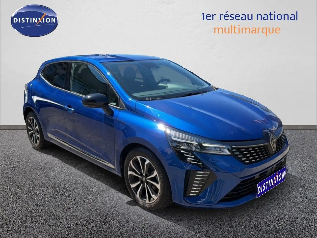 Vue 3/4 avant d'une Renault Clio 2025 bleu iron metal avec jantes alliage et calandre moderne.