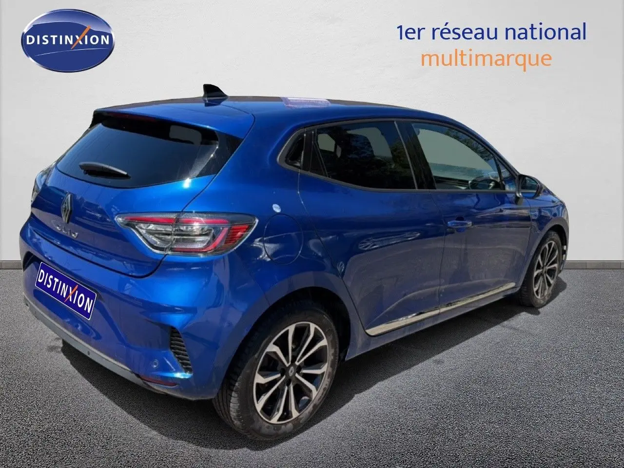Vue 3/4 arrière droite d'une Renault Clio 2025 bleu iron metal avec jantes alliage et vitres teintées.