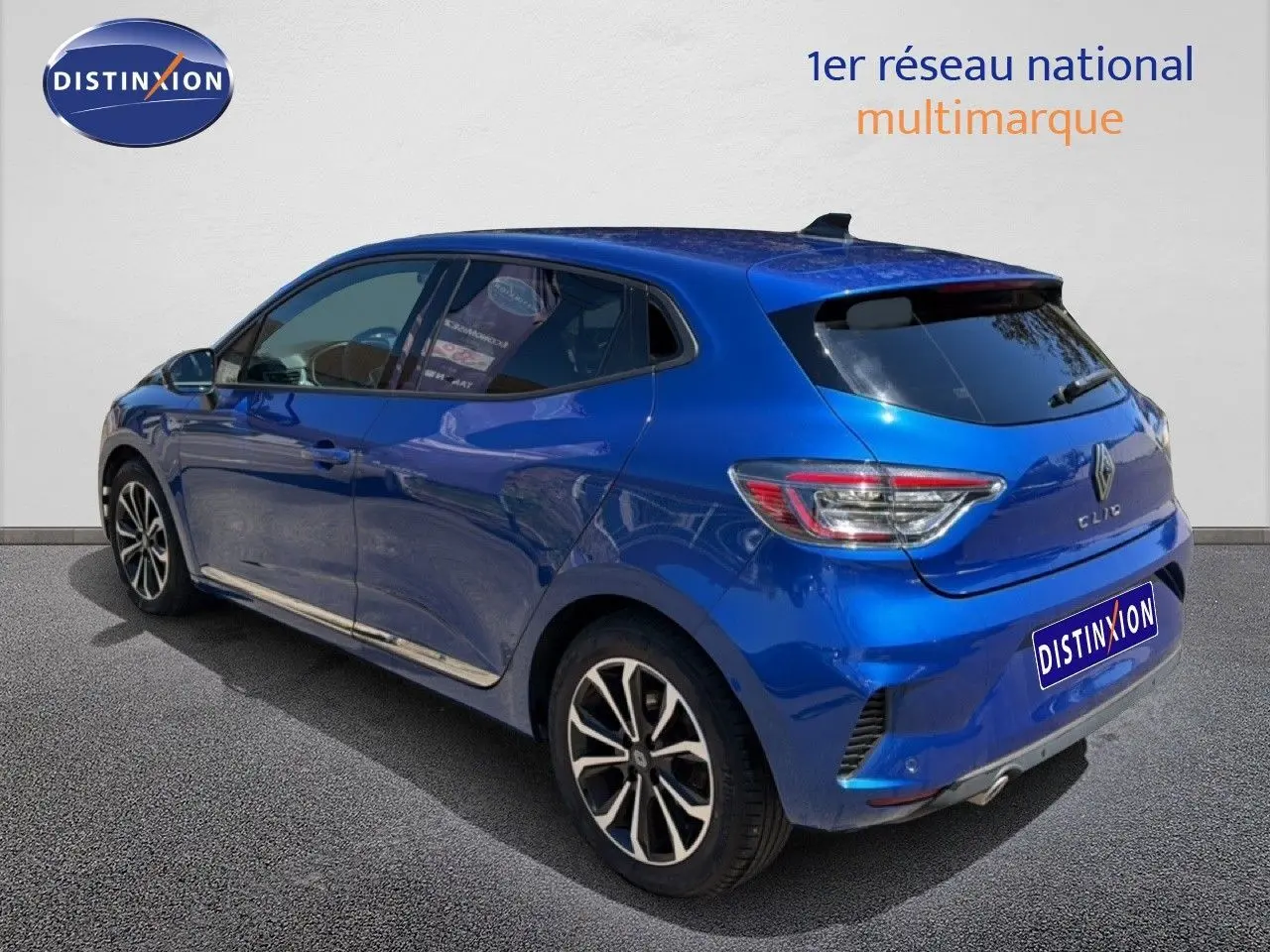 Renault Clio bleu iron metal en 3/4 arrière droit, avec jantes alliage et vitres teintées.