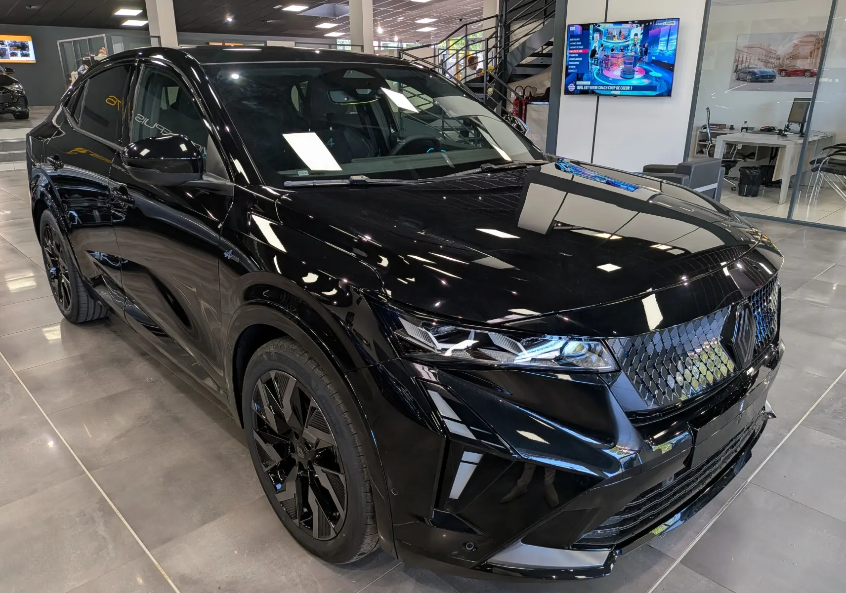 Renault Rafale noir étoilé en 3/4 avant droit, avec calandre à losanges et jantes noires biton élégantes.