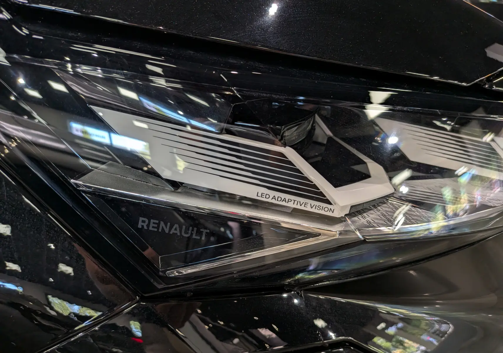 Gros plan sur le phare avant droit noir étoilé du Renault Rafale 2026 avec inscription LED Adaptive Vision.