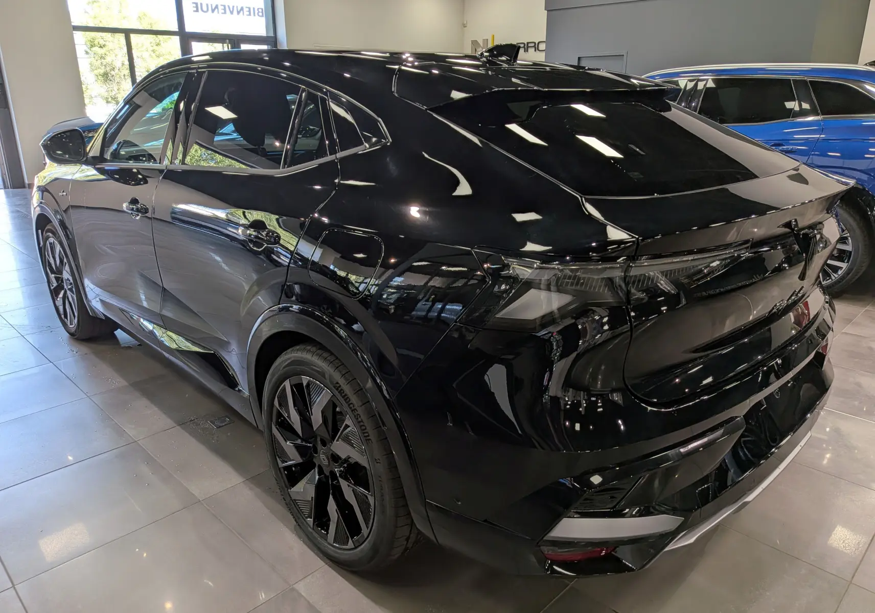 Vue 3/4 arrière droite du Renault Rafale noir étoilé avec jantes biton et lignes fluides en intérieur showroom.