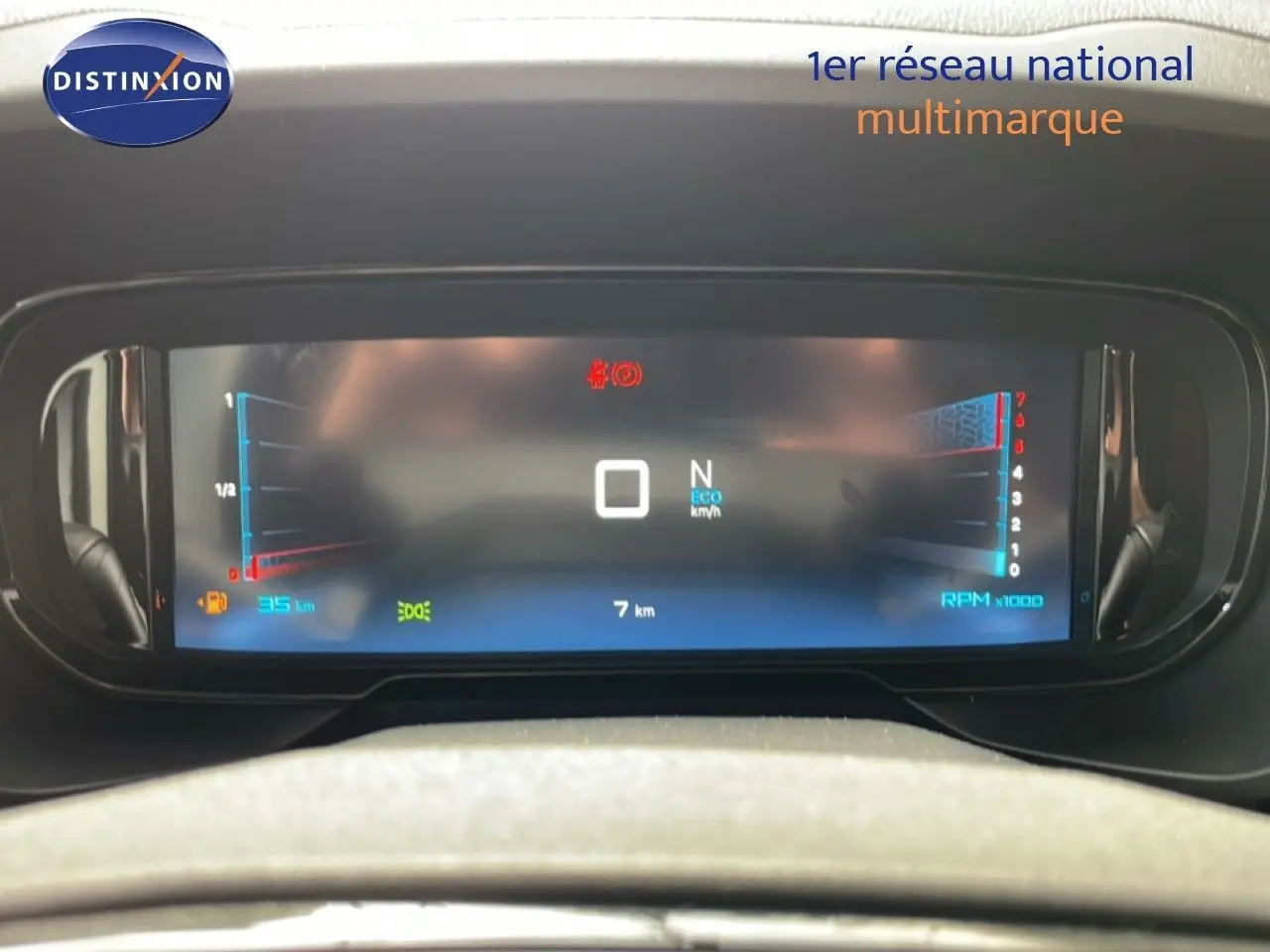 Vue rapprochée du tableau de bord numérique du Citroën Berlingo gris, affichant les compteurs et indicateurs.
