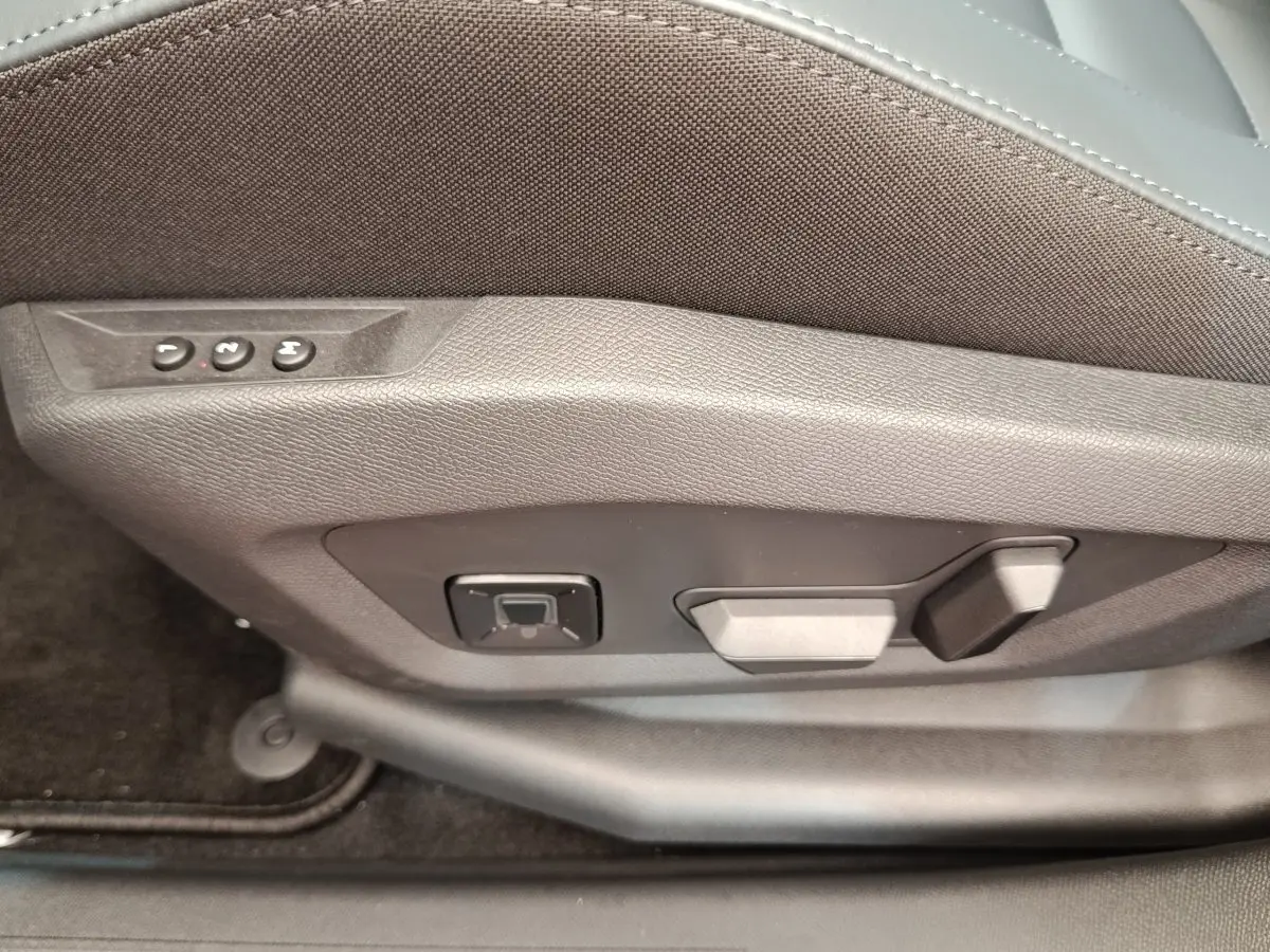 Gros plan sur les commandes de réglage électrique du siège avant droit du Citroën C5 Hybride vert 2026.