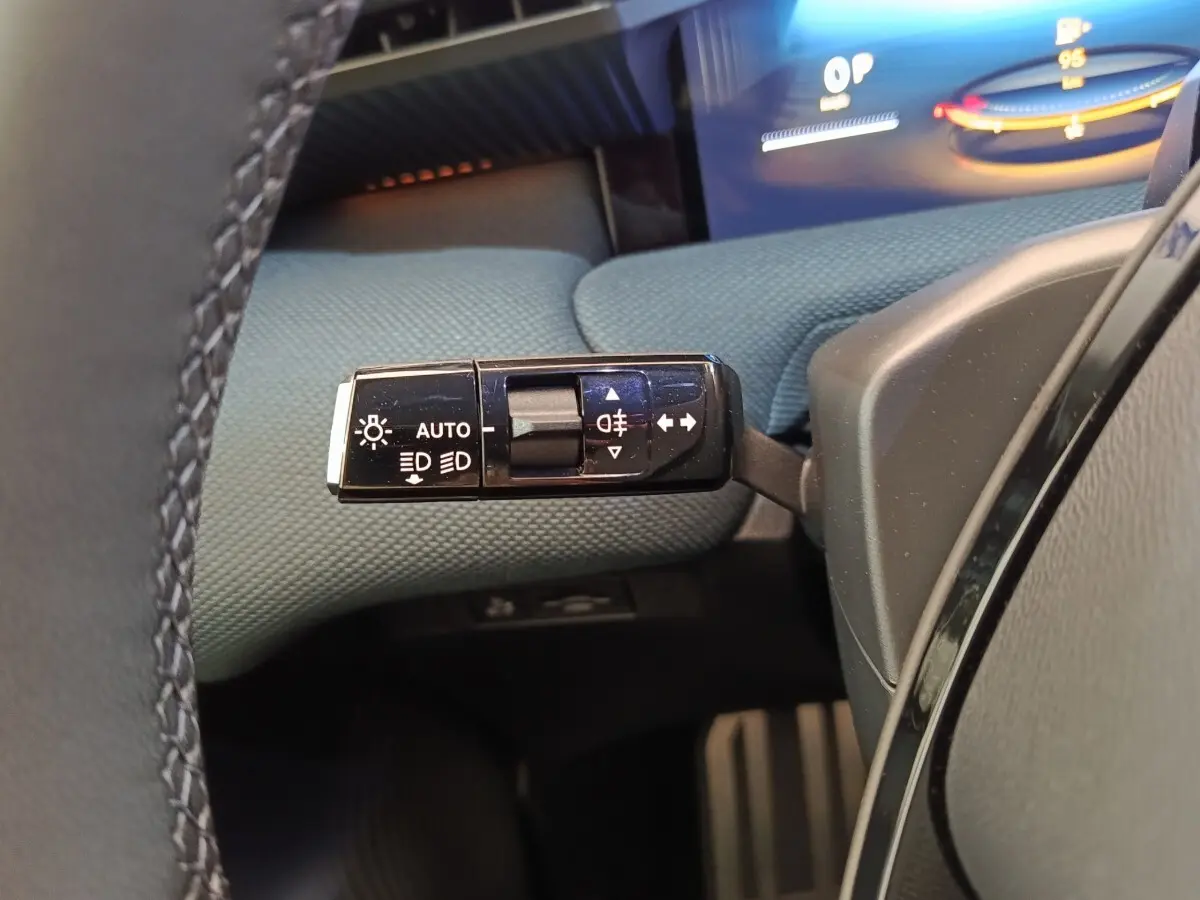 Gros plan sur la commande des feux et clignotants dans l’habitacle du Citroën C5 Hybride 2026, tissu bleu visible.
