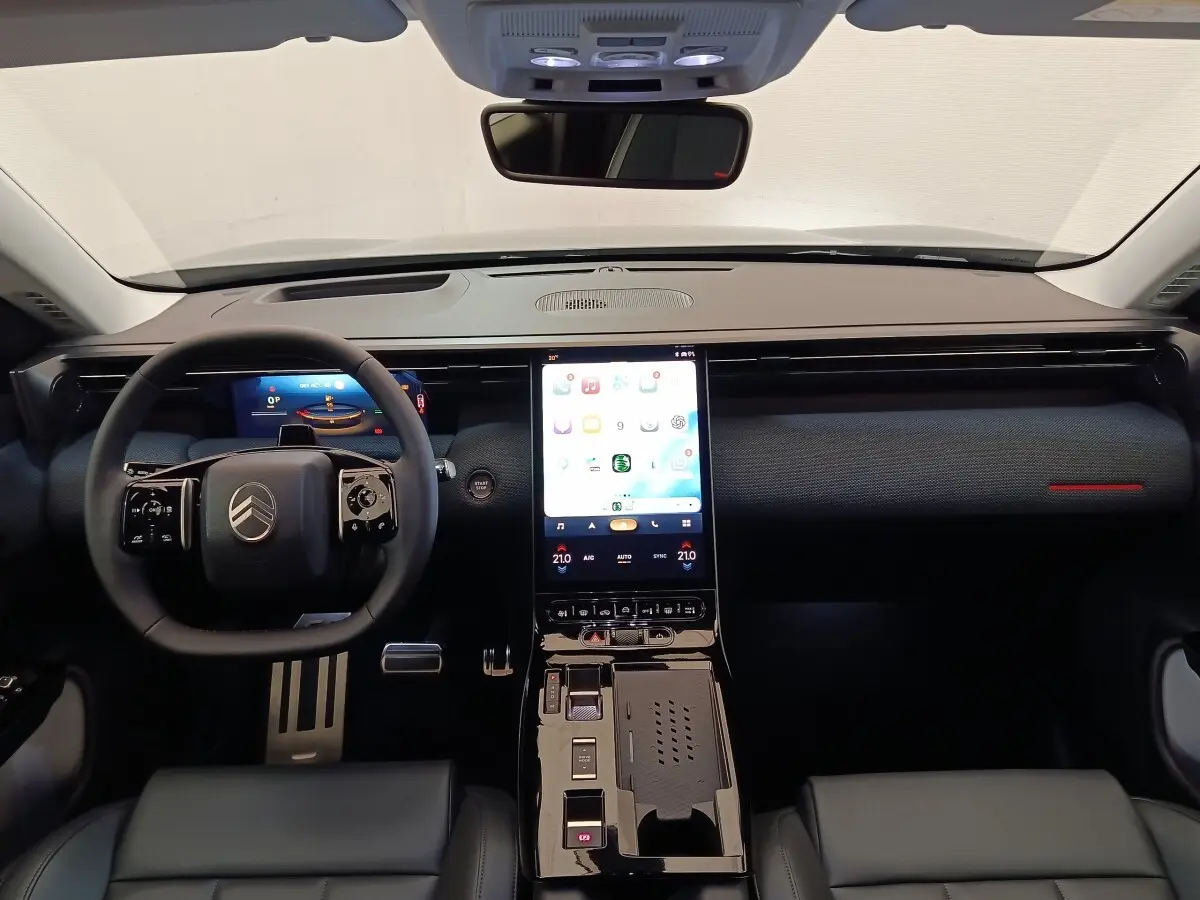 Vue intérieure avant du tableau de bord noir du Citroën C5 Hybride 2026 avec écran tactile vertical central lumineux.