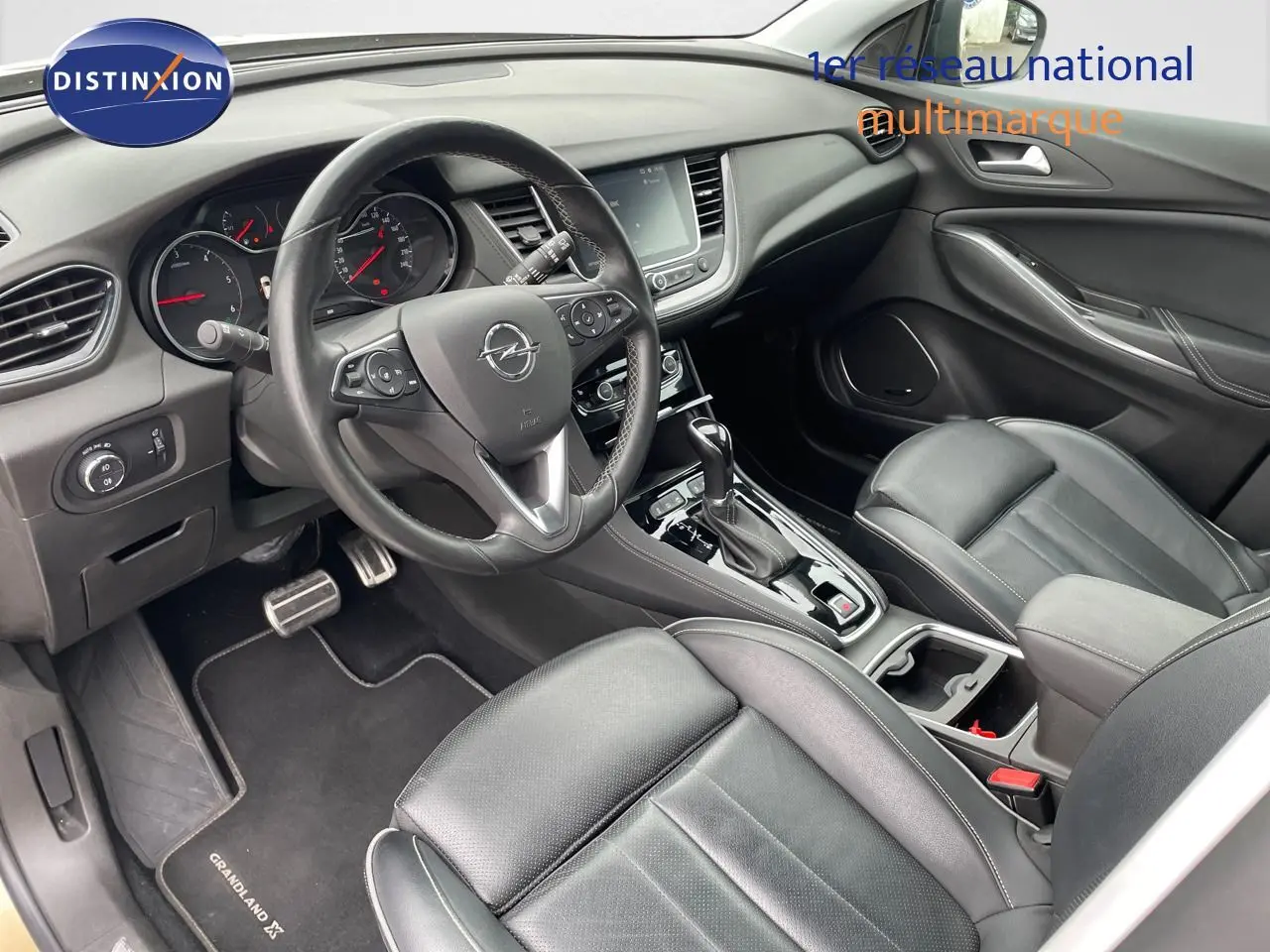 Intérieur avant droit de l'Opel Grandland X 2018 avec sièges cuir noir et console centrale équipée d'une boîte automatique.