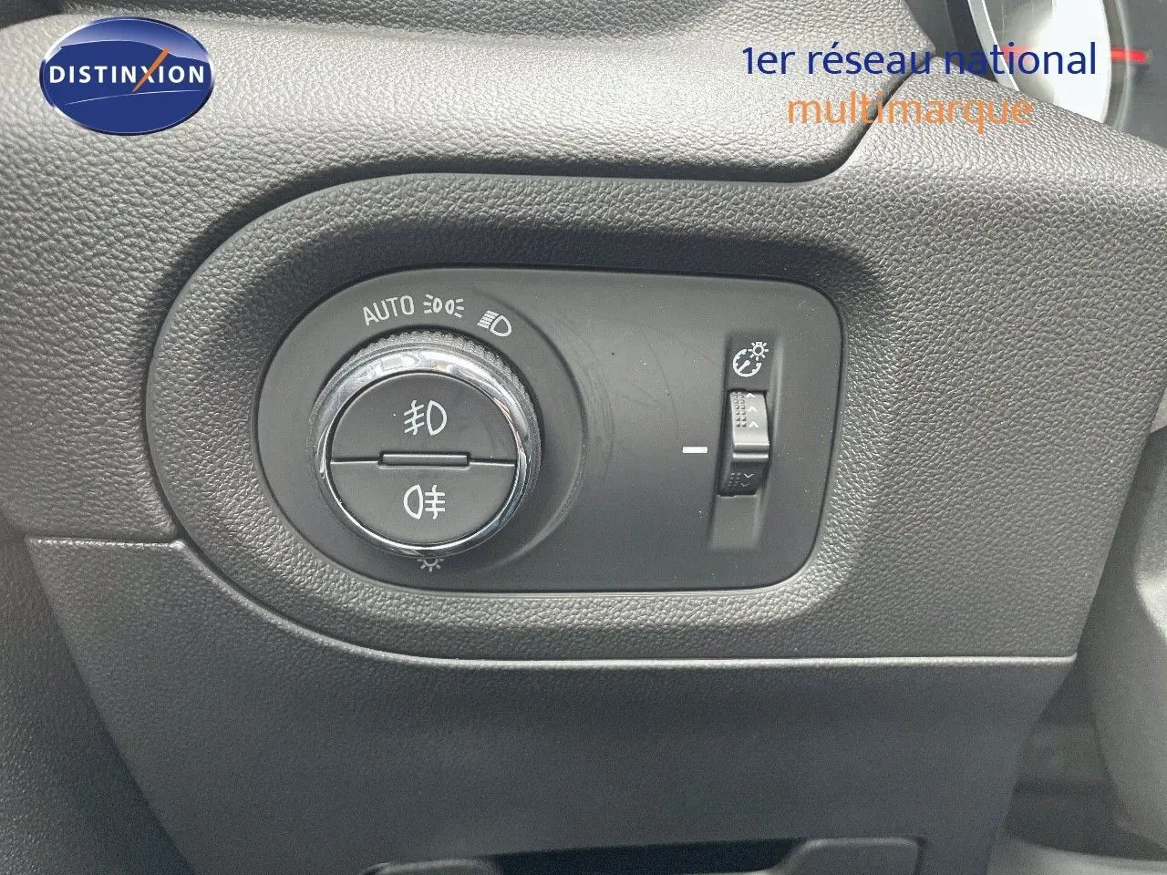 Gros plan sur le bouton de commande des phares et réglage de luminosité dans l'habitacle d'un Opel Grandland X 2018.