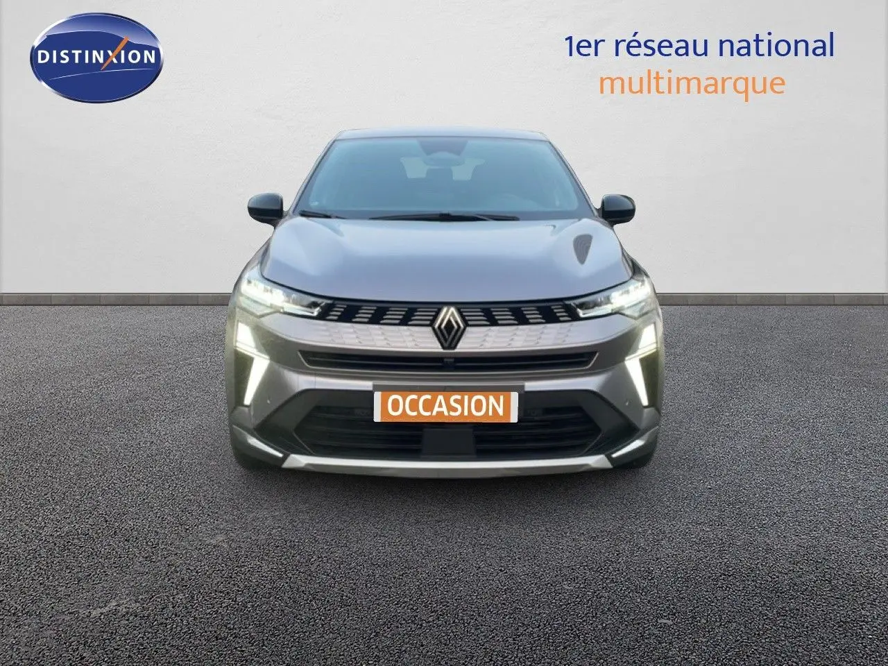 Vue frontale d'une Renault SYMBIOZ gris cassiopée métal avec feux LED allumés sur fond neutre.