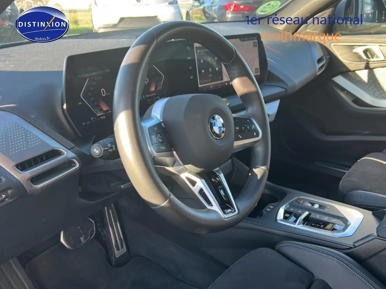 Vue intérieure centrée sur le volant et le tableau de bord numérique de la BMW Série 1 gris Skyscraper.