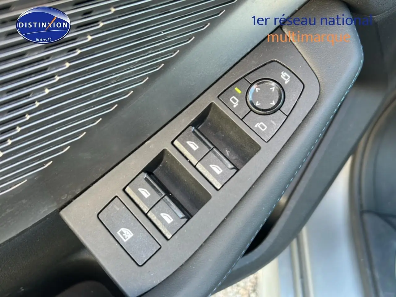 Gros plan sur les commandes des vitres et rétroviseurs côté gauche d'une BMW Série 1 F40 gris Skyscraper.