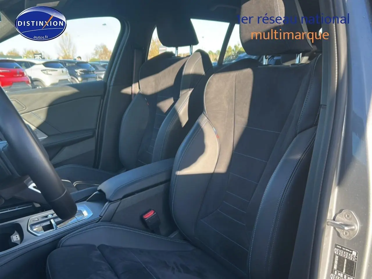 Vue intérieure côté droit sur les sièges avant sport en tissu alcantara noir avec surpiqûres bleues d'une BMW Série 1 gris Skyscraper.