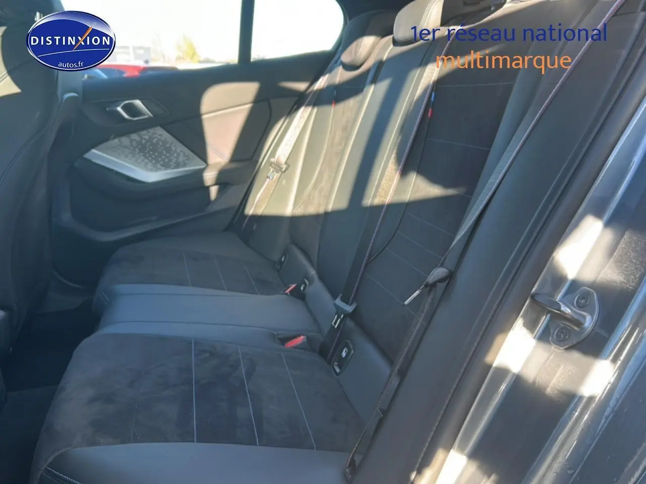 Vue intérieure côté droit des sièges arrière en tissu alcantara noir avec coutures bleues d'une BMW Série 1 gris Skyscraper.