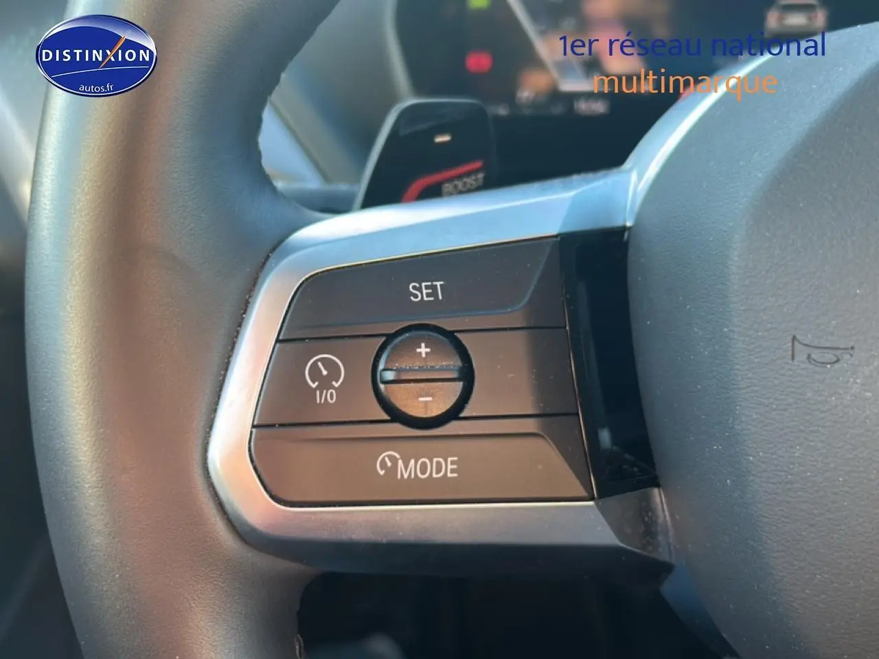 Gros plan sur les commandes de régulateur de vitesse au volant d’une BMW Série 1 gris Skyscraper, version M Sport Pro.